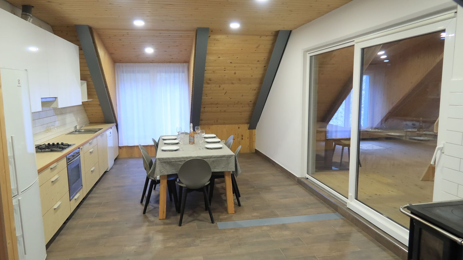 Kitchen and dining area under a timber ceiling in the three-bedroom apartment